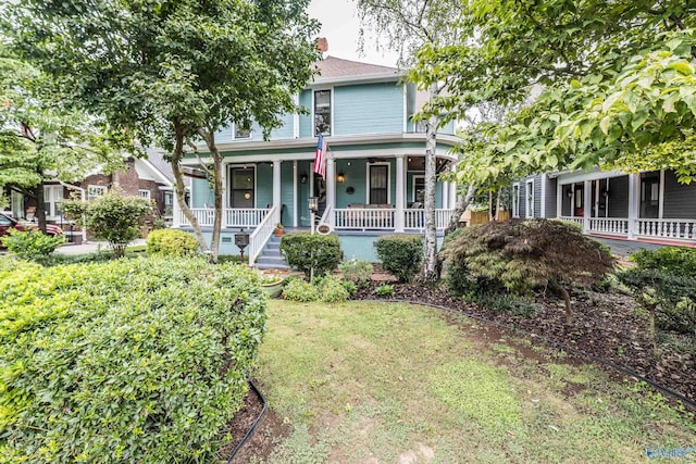 view of front of house featuring a front yard, covered porch, and a chimney