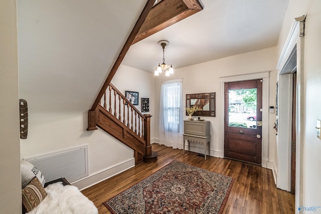 entrance foyer with visible vents, beamed ceiling, wood finished floors, and stairway