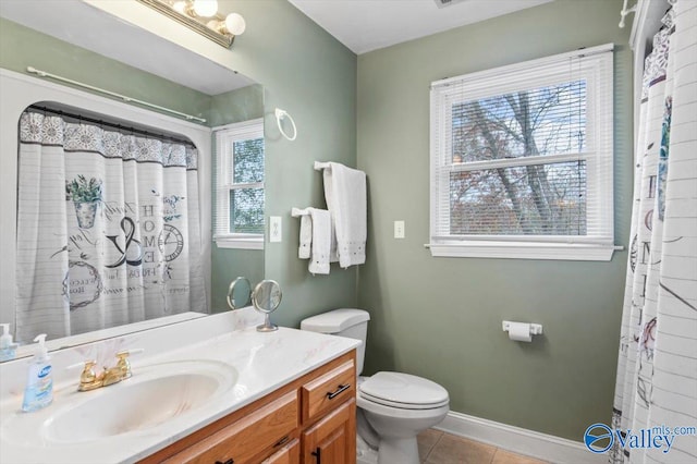 bathroom featuring a wealth of natural light, vanity, toilet, and tile patterned floors