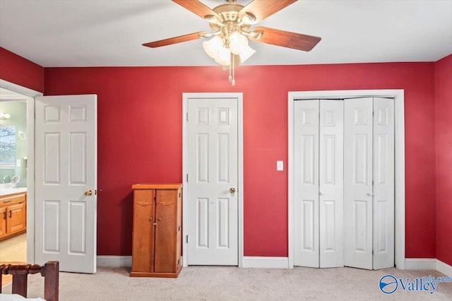 bedroom featuring light colored carpet, connected bathroom, and ceiling fan