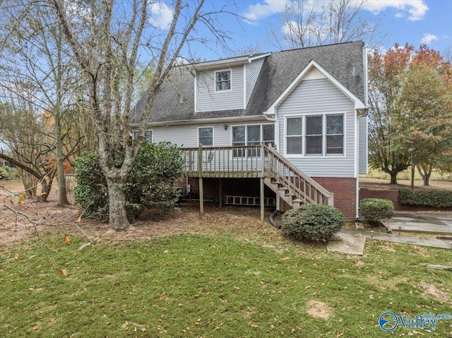 rear view of house featuring a wooden deck and a lawn