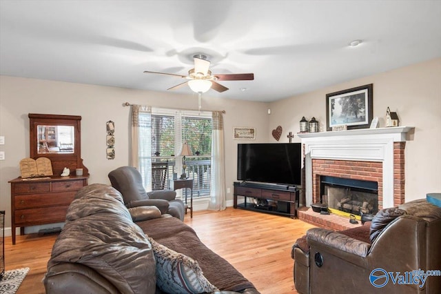 living room featuring ceiling fan, a brick fireplace, and hardwood / wood-style floors