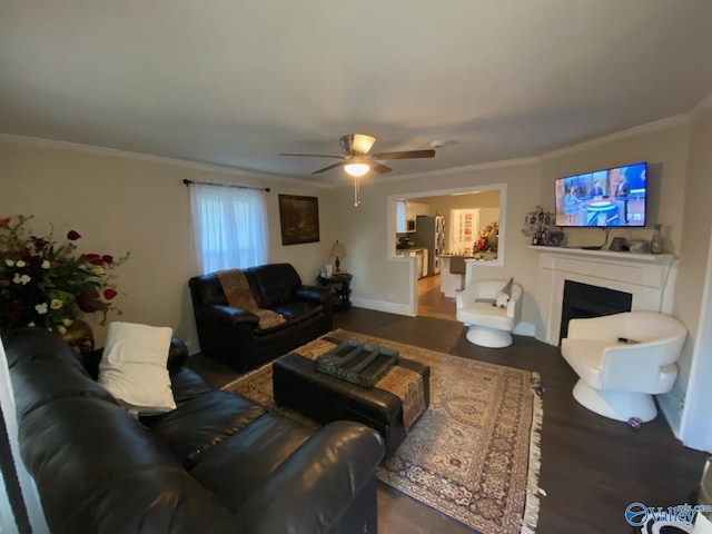 living room featuring ornamental molding, a fireplace, wood finished floors, and baseboards