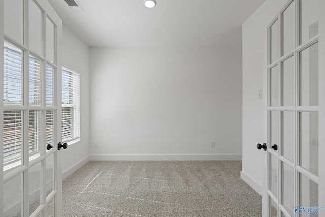 carpeted empty room featuring french doors