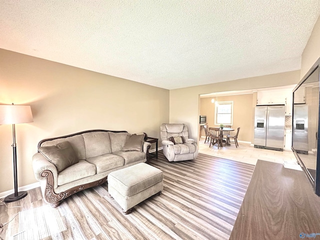 living room featuring light hardwood / wood-style flooring and a textured ceiling