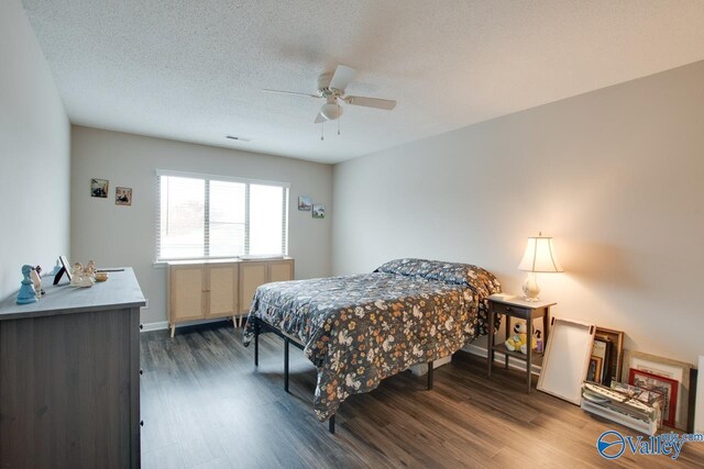 bedroom featuring ceiling fan, dark wood-type flooring, and a textured ceiling