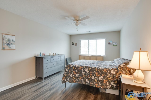 bedroom with a textured ceiling, ceiling fan, and dark wood-type flooring