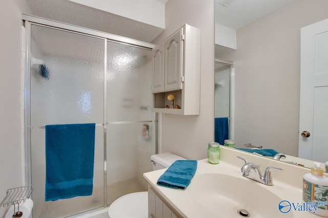 bathroom featuring toilet, vanity, and walk in shower