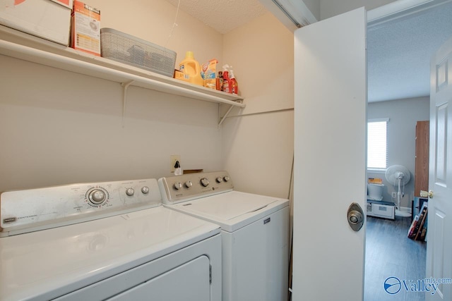 laundry room with washing machine and dryer, hardwood / wood-style floors, and a textured ceiling