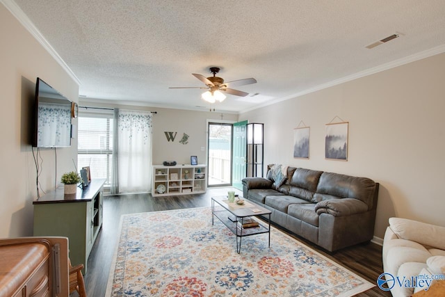 living room featuring plenty of natural light, dark wood-type flooring, and ornamental molding