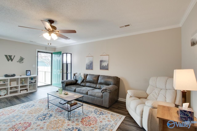 living room with a textured ceiling, dark hardwood / wood-style floors, ceiling fan, and crown molding