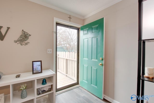 foyer with a textured ceiling, light wood-type flooring, and crown molding