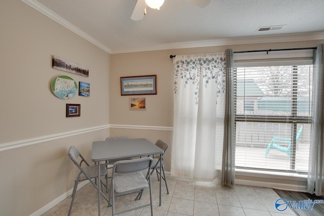 dining room featuring crown molding, light tile patterned flooring, a textured ceiling, and ceiling fan