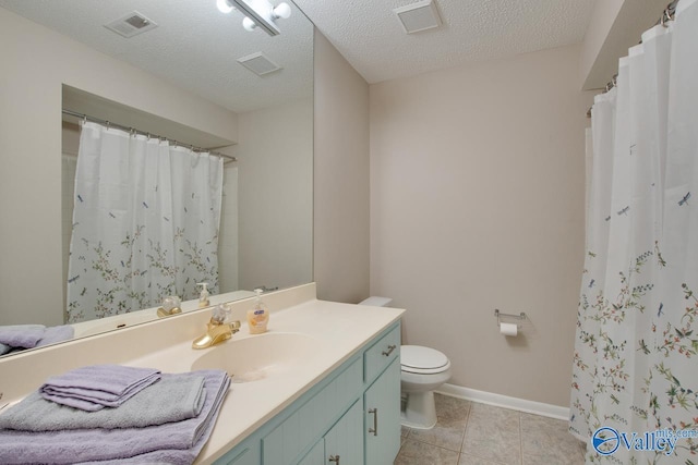 bathroom with tile patterned flooring, vanity, a textured ceiling, and toilet