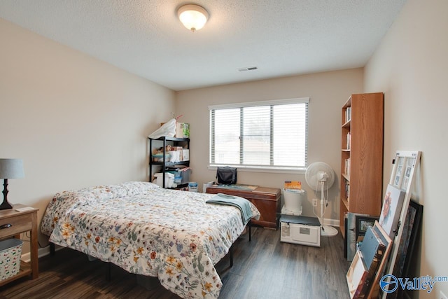 bedroom featuring a textured ceiling and dark hardwood / wood-style floors