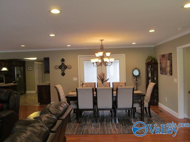 dining space featuring dark hardwood / wood-style floors, ornamental molding, and a notable chandelier