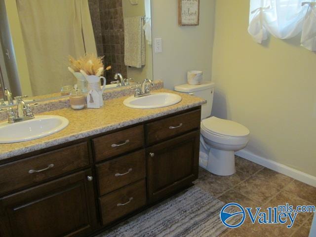 bathroom featuring tile patterned floors, vanity, and toilet