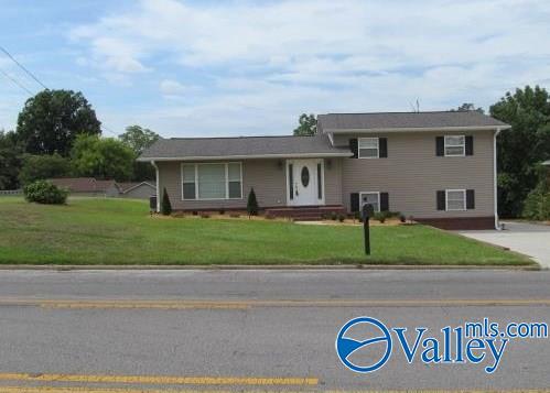 tri-level home with central air condition unit and a front yard