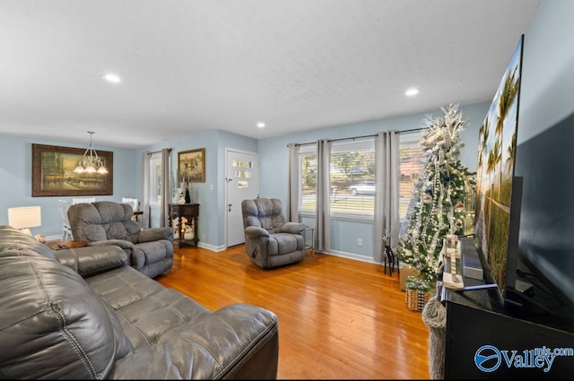 living room with hardwood / wood-style floors and an inviting chandelier