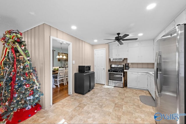 kitchen with white cabinets, ceiling fan with notable chandelier, and stainless steel appliances