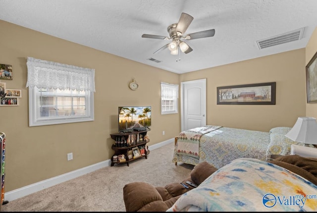 bedroom featuring carpet flooring, a textured ceiling, and ceiling fan