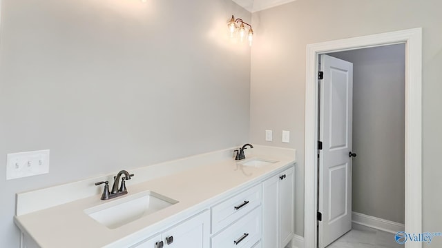 bathroom featuring baseboards, marble finish floor, and a sink