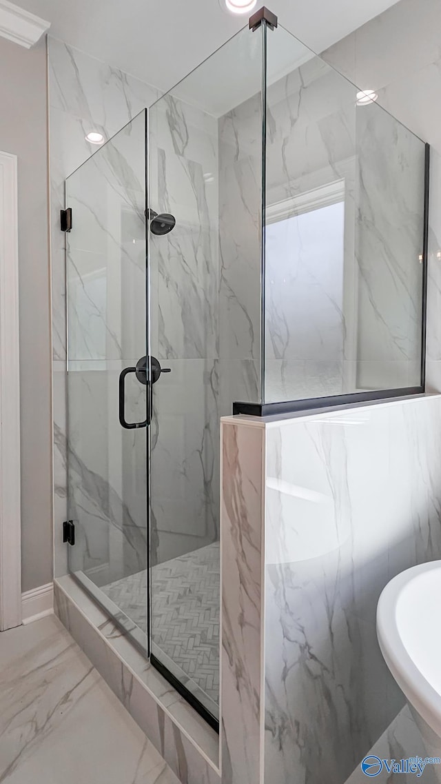 full bath featuring a marble finish shower, marble finish floor, and a sink