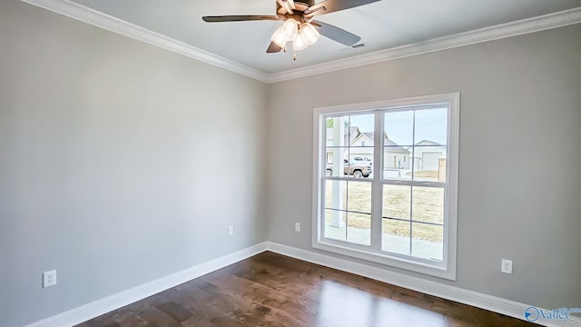 empty room featuring dark wood finished floors, crown molding, plenty of natural light, and baseboards