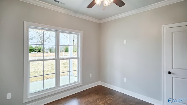 spare room featuring baseboards, dark wood-type flooring, ornamental molding, and plenty of natural light