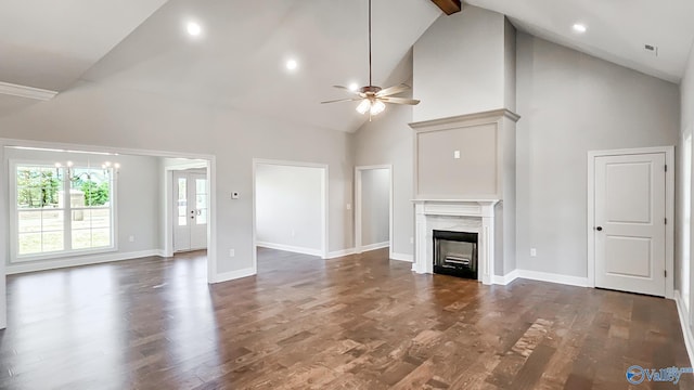 unfurnished living room featuring dark wood-type flooring, ceiling fan with notable chandelier, baseboards, and a premium fireplace