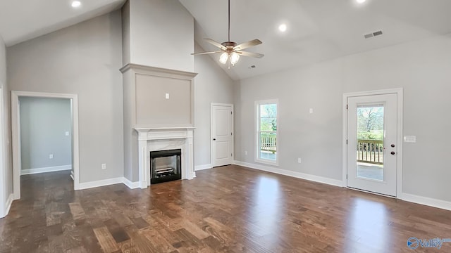 unfurnished living room featuring a high end fireplace, visible vents, plenty of natural light, and dark wood finished floors