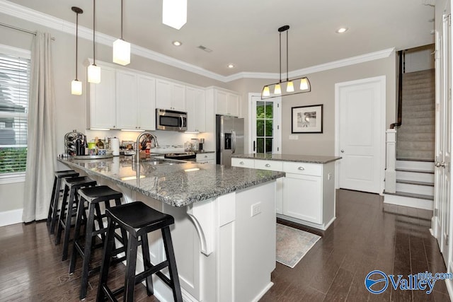 kitchen featuring appliances with stainless steel finishes, plenty of natural light, and white cabinetry