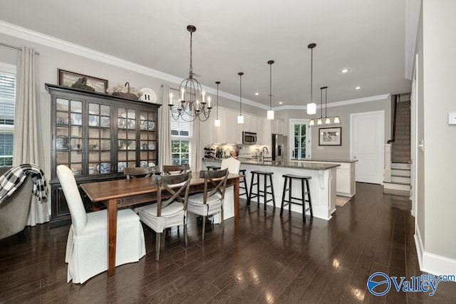 dining space with a notable chandelier, ornamental molding, dark wood-type flooring, and sink