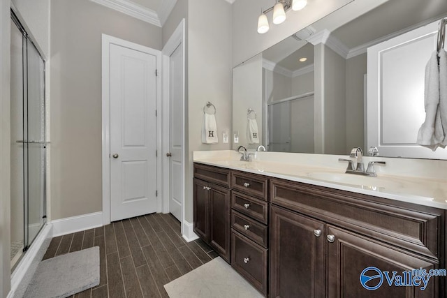 bathroom with wood-type flooring, vanity, a shower with shower door, and ornamental molding