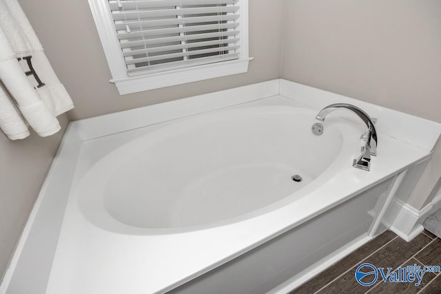 bathroom with hardwood / wood-style flooring and a bathing tub