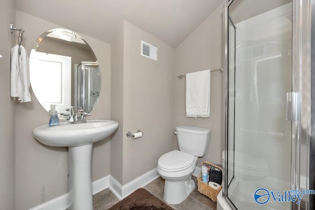 bathroom with vaulted ceiling, walk in shower, tile patterned floors, and toilet