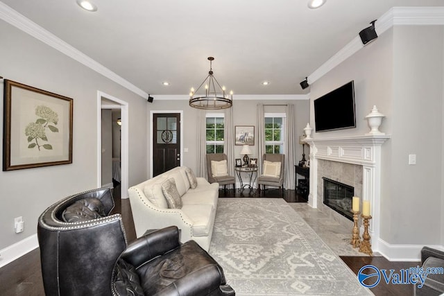 living room with crown molding, a fireplace, dark hardwood / wood-style flooring, and a chandelier