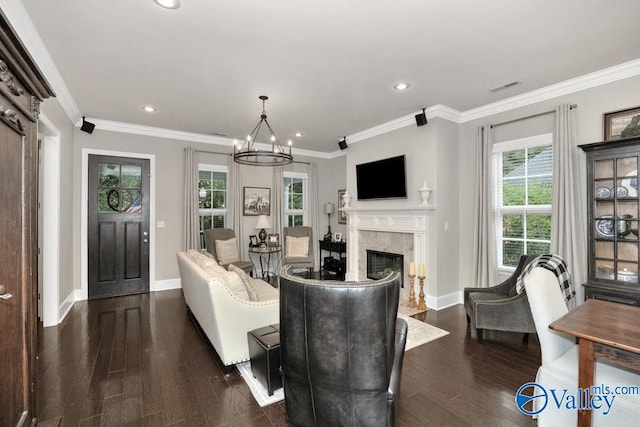 living room featuring ornamental molding, a chandelier, a fireplace, and dark hardwood / wood-style flooring