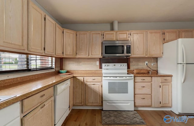 kitchen with light wood-type flooring, white appliances, light countertops, and light brown cabinets