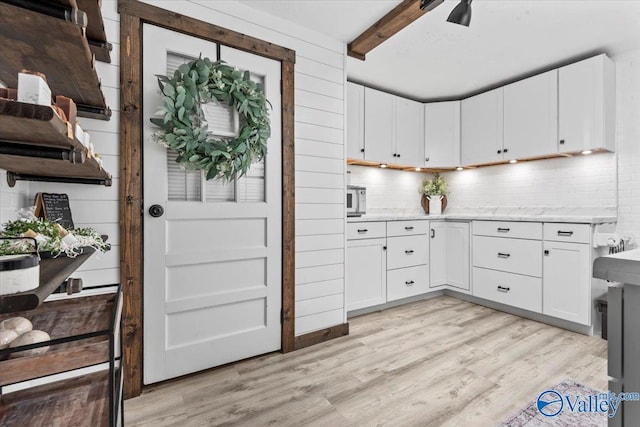 1081 County Road 190, Moulton, AL 35650 - kitchen with tasteful backsplash, light wood finished floors, beam ceiling, white cabinets, and a ceiling fan