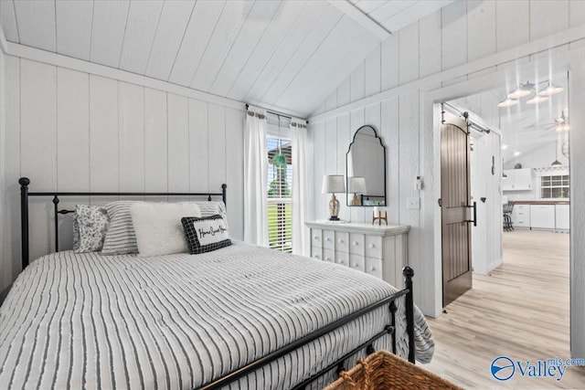 1081 County Road 190, Moulton, AL 35650 - bedroom with vaulted ceiling, wood finished floors, a barn door, and wooden walls