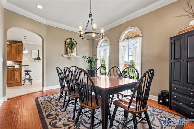 1081 County Road 190, Moulton, AL 35650 - dining room with arched walkways, light wood finished floors, crown molding, a chandelier, and baseboards
