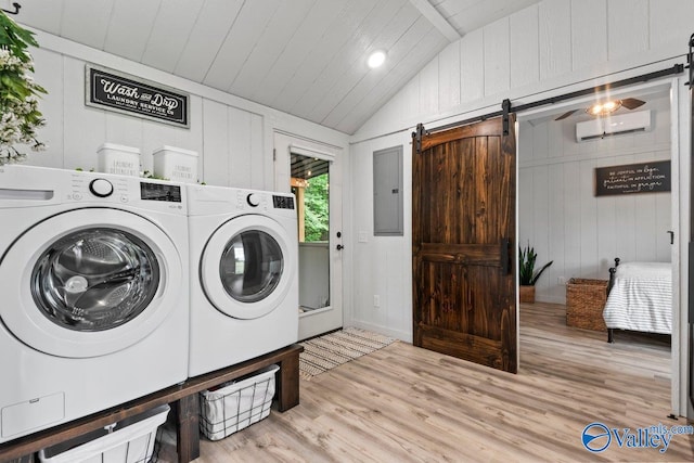 1081 County Road 190, Moulton, AL 35650 - laundry area featuring washing machine and clothes dryer, a barn door, a wall unit AC, and wood finished floors