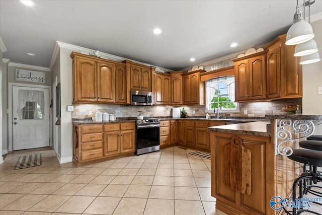 1081 County Road 190, Moulton, AL 35650 - kitchen with appliances with stainless steel finishes, crown molding, a peninsula, brown cabinets, and light tile patterned floors