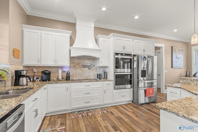 kitchen featuring white cabinetry, sink, decorative backsplash, appliances with stainless steel finishes, and custom exhaust hood