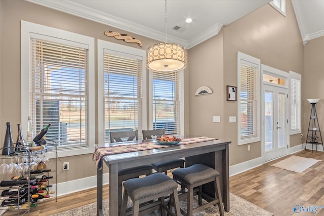 dining area featuring ornamental molding, french doors, and light hardwood / wood-style flooring