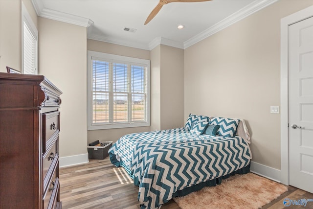 bedroom featuring light hardwood / wood-style flooring, ceiling fan, and ornamental molding