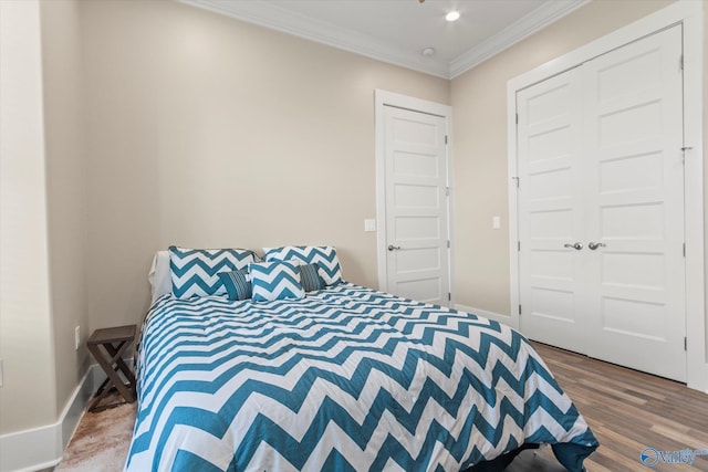 bedroom with a closet, wood-type flooring, and ornamental molding