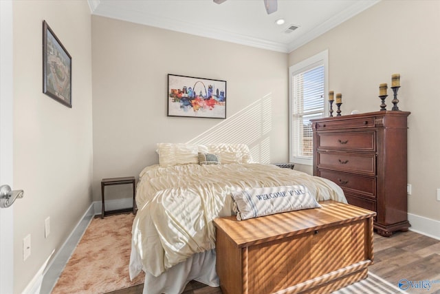 bedroom featuring light hardwood / wood-style flooring, ceiling fan, and ornamental molding