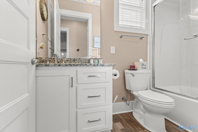 full bathroom with hardwood / wood-style floors, vanity, toilet, and combined bath / shower with glass door